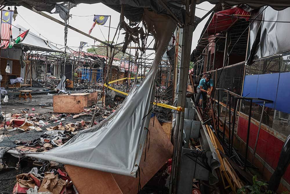 Beberapa pekerja cuba memasuki deretan gerai yang musnah di bazar larut malam (Uptown) Kota Damansara yang terbakar kira-kira 90 peratus dalam satu kejadian pada malam, Isnin. - Foto Bernama