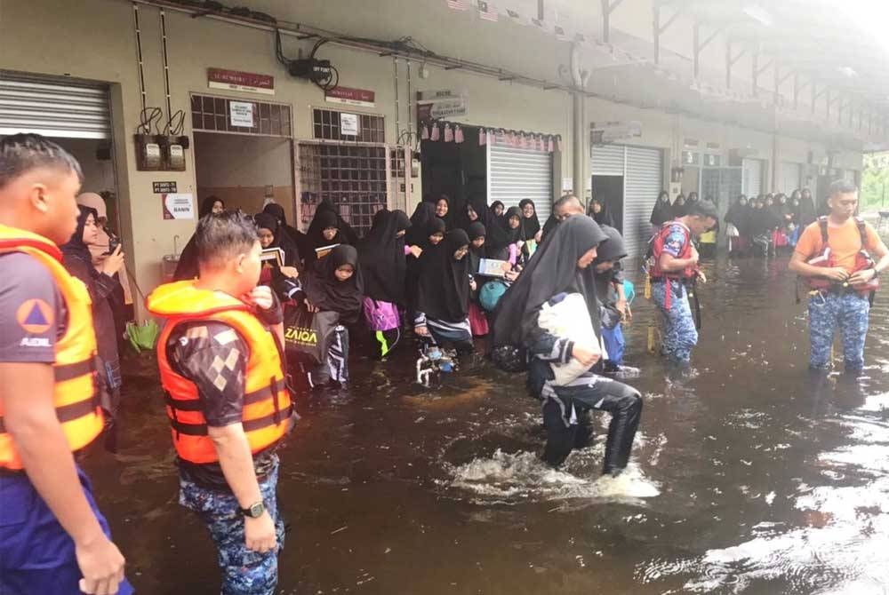 Pelajar SM Imtiaz Kuala Nerus dipindahkan ke PPS oleh anggota penyelamat selepas kawasan sekitar pusat pengajian itu dinaiki air.