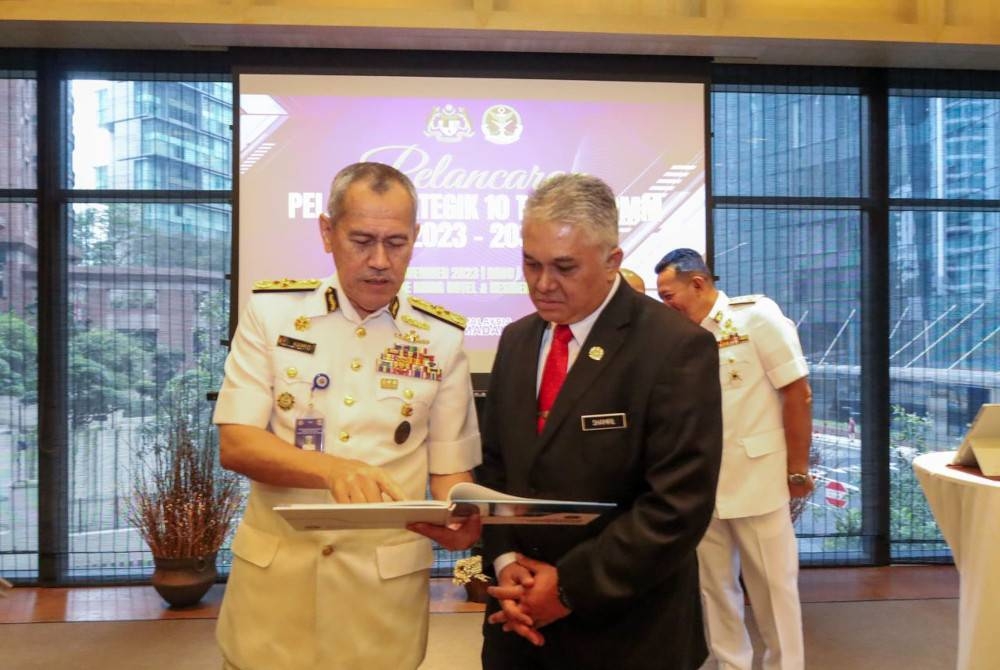 Hamid (kiri) melihat pelan strategik yang dilaksanakan Maritim Malaysia dalam usaha perkasa agensi itu.