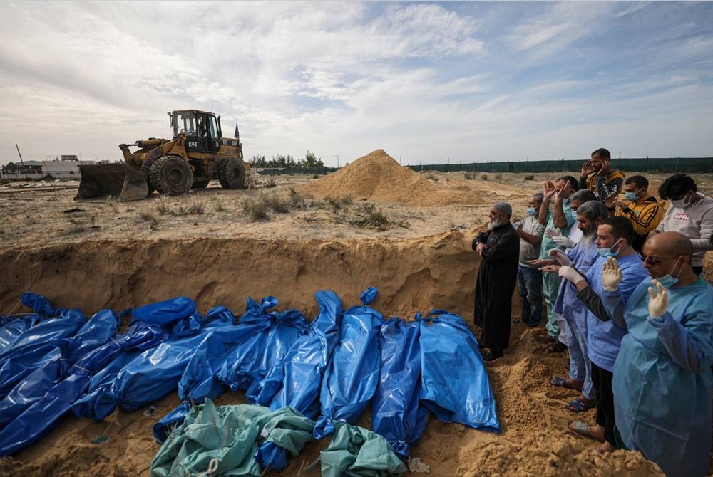 Penduduk Palestin menunaikan solat jenazah terhadap mangsa yang terbunuh dalam serangan Israel ke atas Gaza di tanah perkuburan Khan Younis di selatan Semenanjung Gaza. - Foto EPA