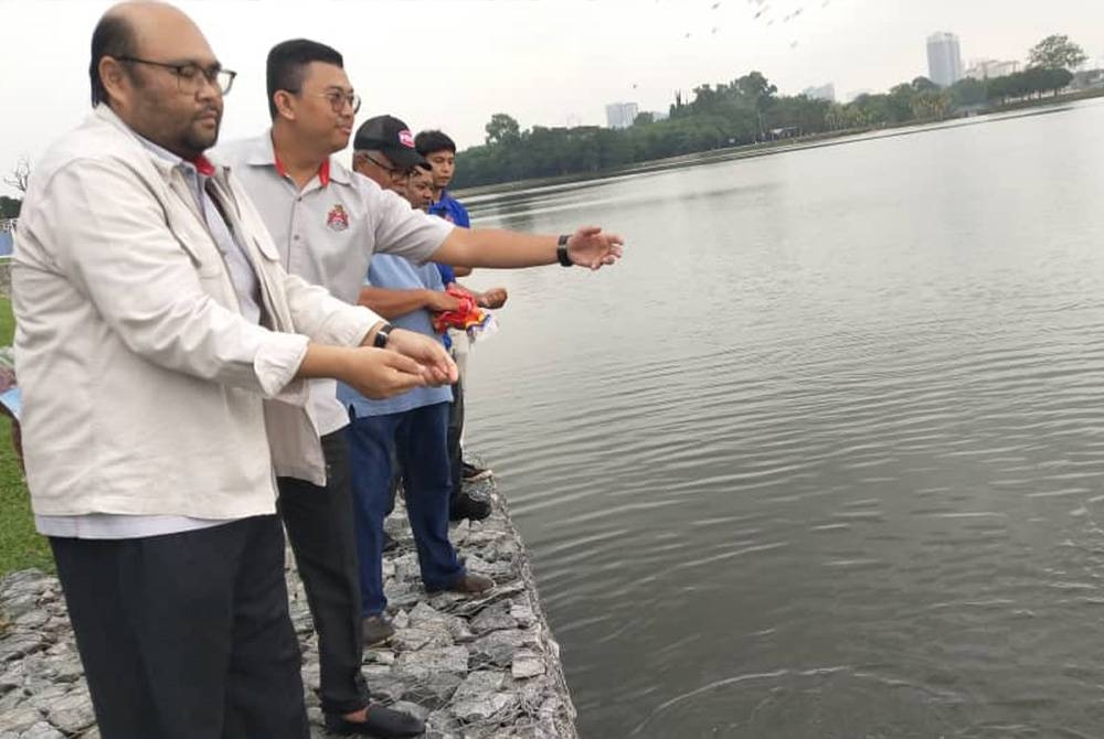 Muhammad Fauzi (depan) meninjau persiapan pertandingan memancing Santai Joran Kuala Lumpur di Taman Tasik Metropolitan, Kepong pada Ahad ini.