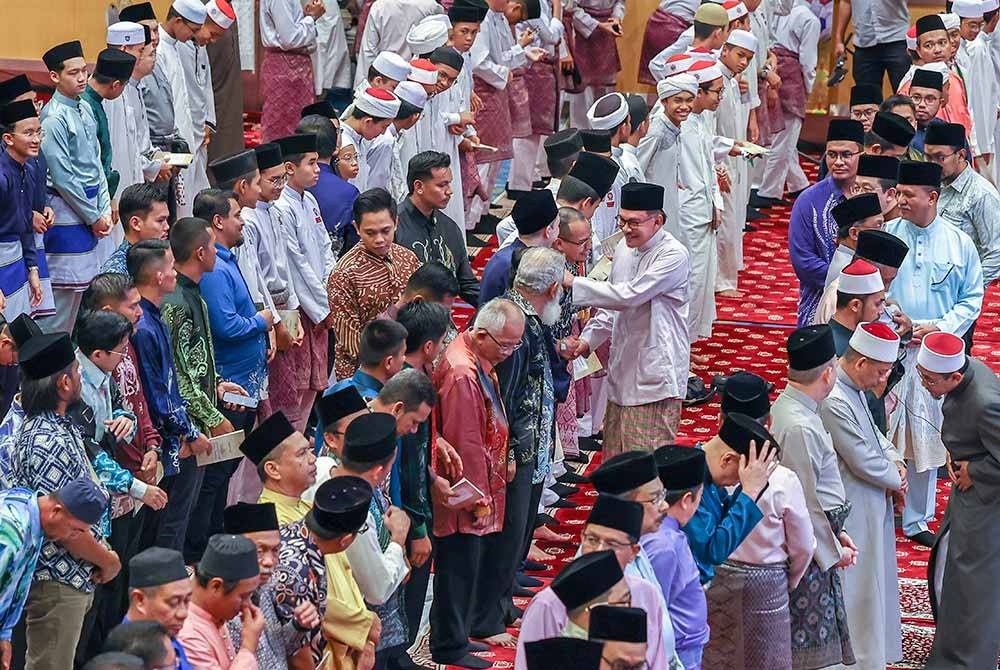 Anwar menyantuni jemaah semasa majlis Kesyukuran Setahun Pentadbiran Perdana Menteri Datuk Seri Anwar Ibrahim dan Kerajaan Madani di Perbadanan Putrajaya malam Khamis. - Foto Bernama