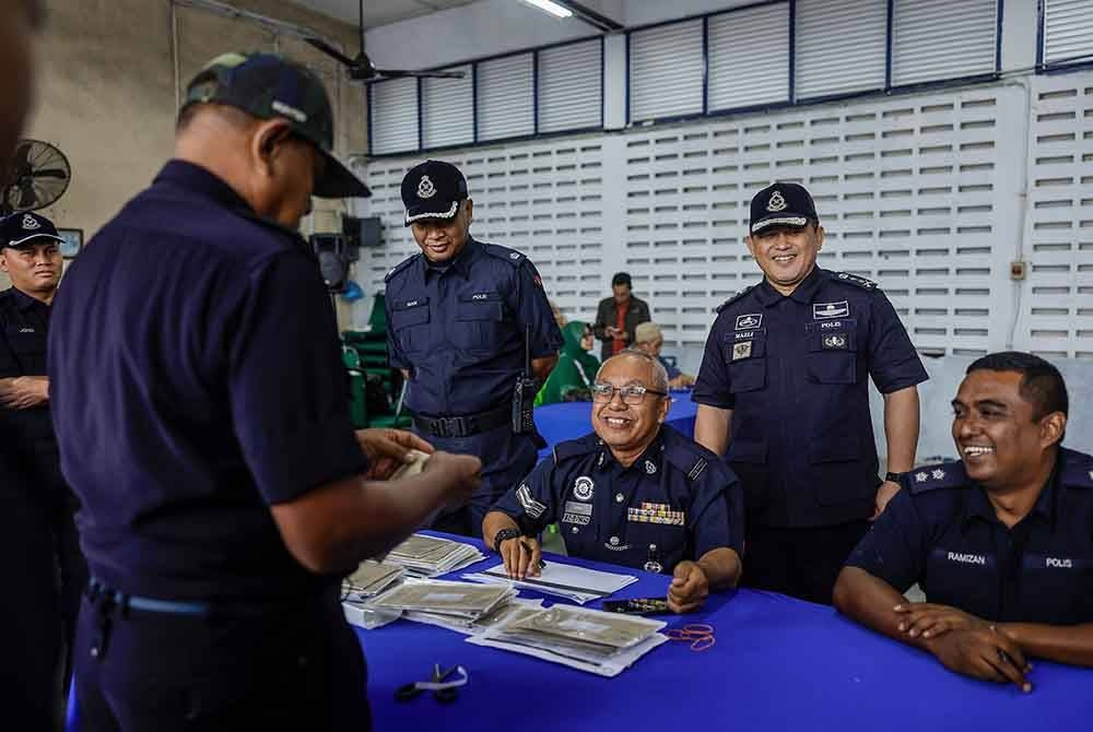 Mazli (dua dari kanan) meninjau anggota polis menunaikan tanggungjawab mengundi pos bagi PRK Parlimen Kemaman ketika tinjauan di Ibu Pejabat Polis Daerah Kemaman, pada Jumaat. - Foto Bernama