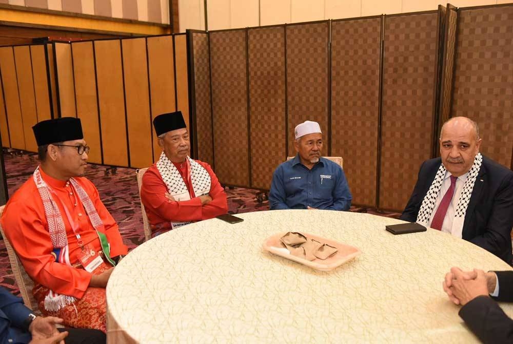 Muhyiddin (dua dari kiri) bersama Timbalan Presiden Bersatu, Datuk Seri Ahmad Faizal Azumu (kiri), Timbalan Presiden Pas, Datuk Seri Tuan Ibrahim Tuan Man (dua kanan) dan Duta Besar Palestin ke Malaysia, Walid Abu Ali berbual mesra sebaik tiba di Perhimpunan Agung Tahunan Bersatu 2023 pada Jumaat.