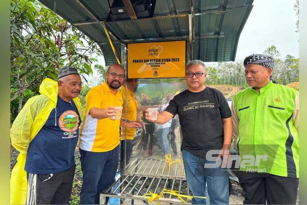 Zafri (dua dari kiri) dan Zawahir (dua dari kanan) menunjukkan air bersih hasil Projek Bekalan Air Bersih Etiqa dengan kerjasama Islamic Aid Malaysia.