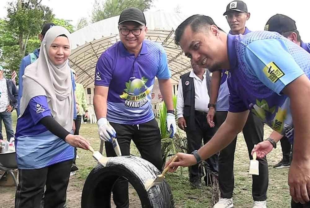 Fadzli (tengah) turut serta mengecat tayar pada Program Anak Muda Pahang Sayang Bumi di Pantai Anak Air pada Sabtu.