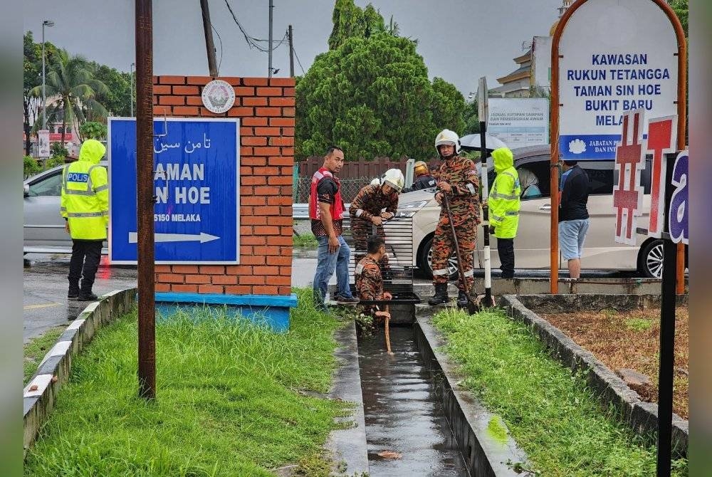 Anggota bomba dan polis sedang melakukan operasi SAR di kawasan mangsa dipercayai terjatuh di longkang Taman Goodwood, Bukit Palah pada petang Sabtu.