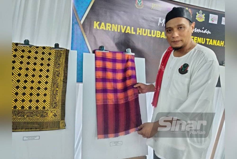 Ahmad Basri menunjukkan kain tenun punca potong yang berusia lebih 200 tahun pada Karnival Hulubaley Bersenu Tanah Jawi 2023.