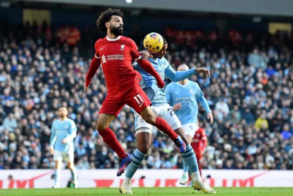 Mohamed Salah (kiri) berebut bola dengan pemain City dalam aksi EPL pada Sabtu.