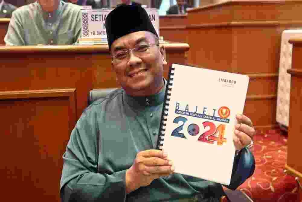 Sanusi menunjukkan buku Bajet 2024 di persidangan Dewan Undangan Negeri (DUN) Kedah pada Ahad.