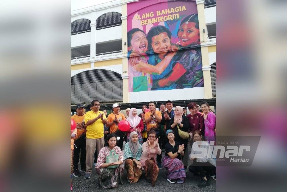 Noraini bersama peserta Heritage Walk pada mural Klang Bahagia Berintegriti di Jalan Stesen di sini.