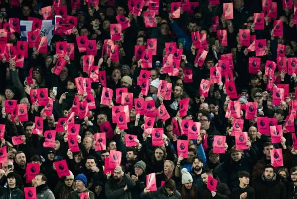 Penyokong Everton melakukan protes ketika perlawanan EPL menentang Manchester United. - Foto AFP