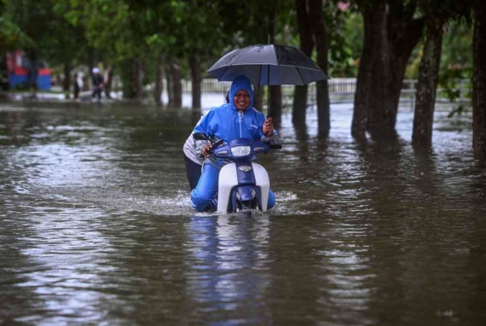 Penduduk meredah banjir ketika tinjauan di Kampung Gong Tok Nasek, Kuala Terengganu pada Rabu lalu. - Foto Bernama