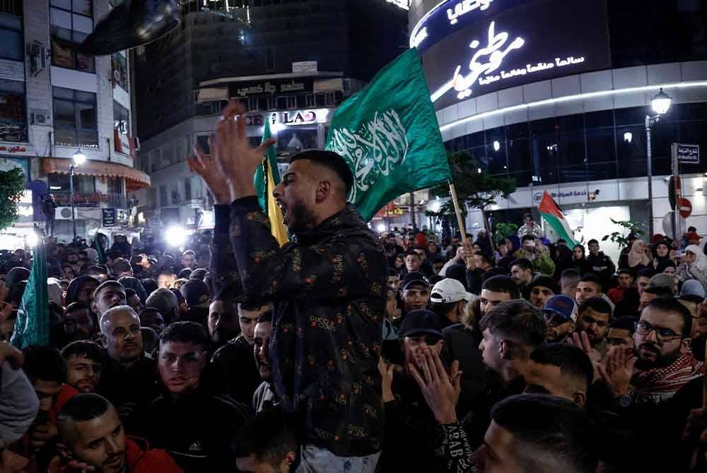 Rakyat Palestin disambut oleh orang ramai selepas dibebaskan dari penjara Israel sebagai pertukaran tebusan yang dibebaskan oleh Hamas dari Semenanjung Gaza, di Ramallah di Tebing Barat yang diduduki pada Ahad. - Foto AFP