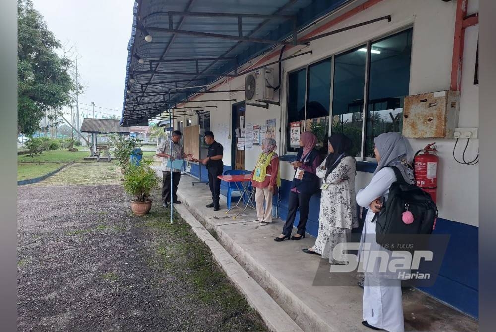 Petugas Suruhanjaya Pilihan Raya membuat persiapan di pusat mengundi awal di Balai Polis Kijal.