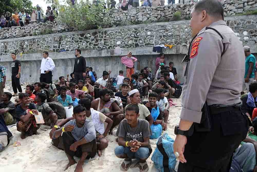 Pelarian Rohingya menunggu di kawasan lapang selepas tiba di pantai di Ujong Kareung, Pulau Weh, Sabang, Indonesia pada Rabu lalu. - EPA