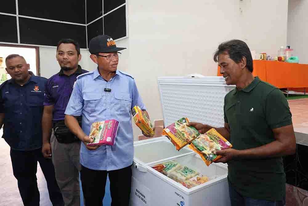 Shabery (tiga dari kiri) meninjau makanan sejuk beku seperti kuih yang turut disediakan di Pusat Pemindahan Sementara (PPS) pada Majlis Pelancaran Felda Siap Siaga 2023 Peringkat Kebangsaan di Felda Seberang Tayor pada Selasa. - Foto Bernama