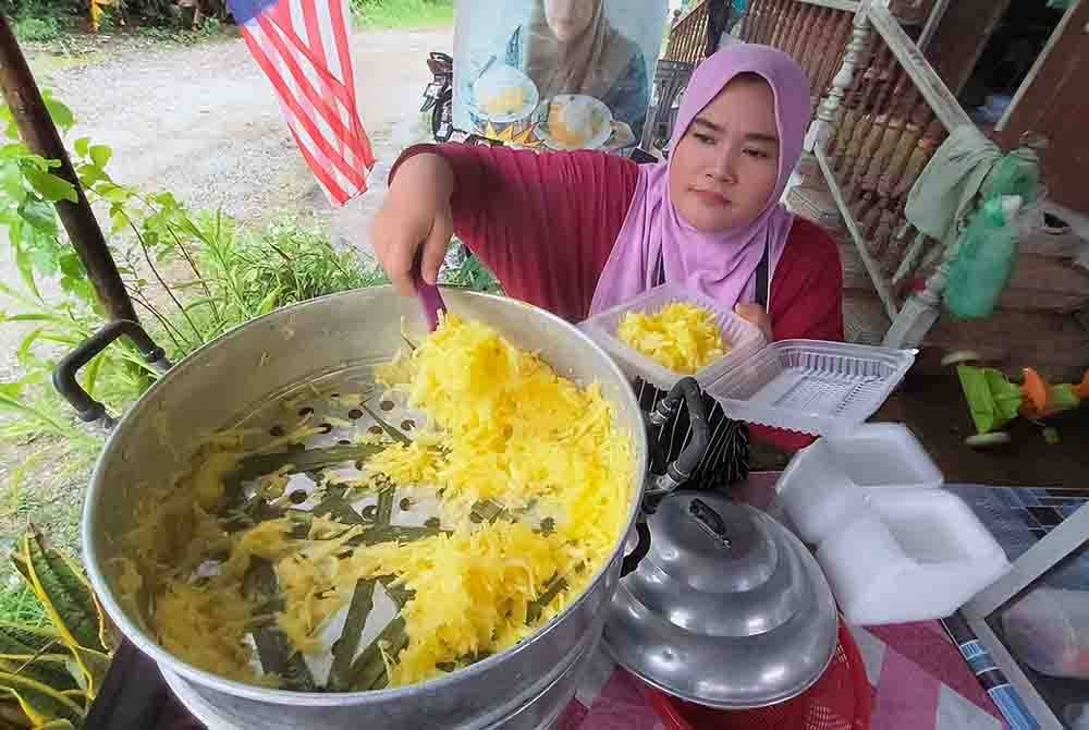 Nor Harlizam mengisi hidangan musim tengkujuh dikenali sebagai &#039;ubi tonyoh&#039; yang dijual di kedainya di Kampung Bunut Sarang Burung, pada Selasa. - Foto Bernama