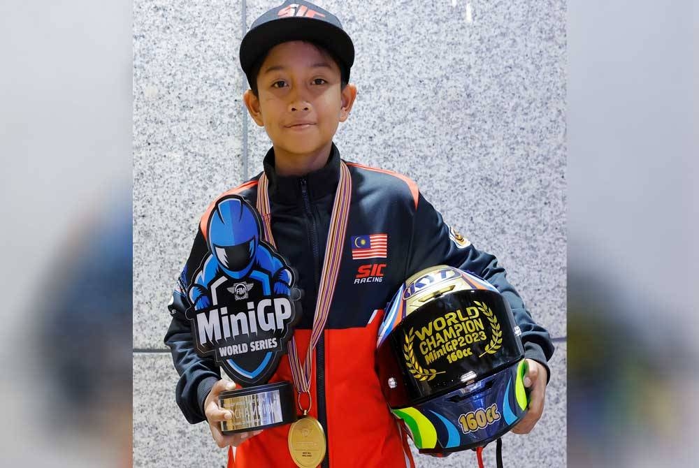 Qabil bersama piala Kejohanan Motosikal Siri Dunia FIM MiniGP tiba di KLIA Terminal 1, pada Selasa. (Gambar kecil: Azlan) - Foto Bernama