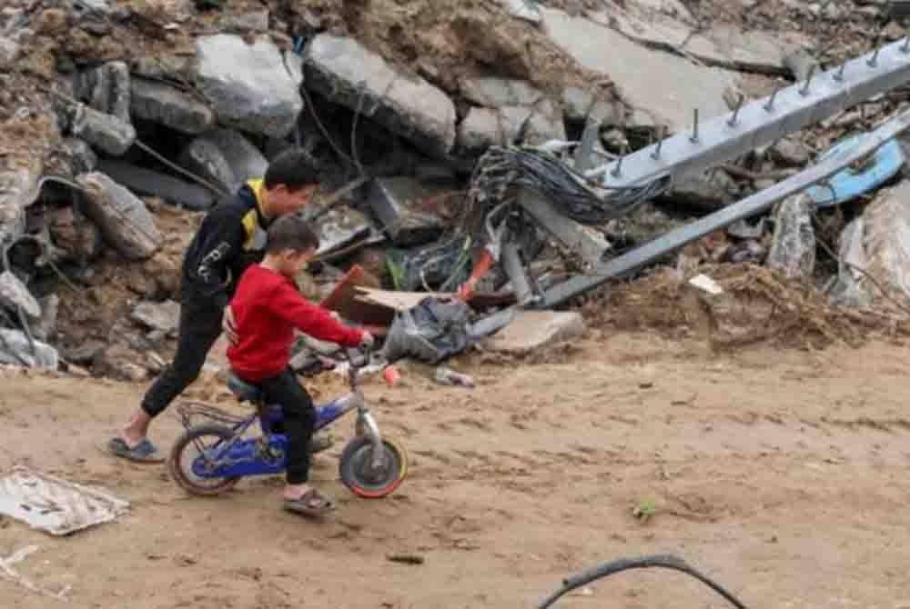 Kanak-kanak warga Palestin bermain berdekatan runtuhan bangunan di Jebaliya. - Foto AP