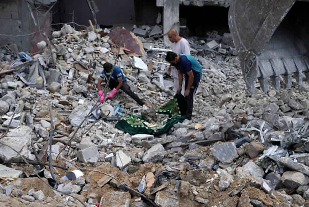 Penduduk Palestin menemui mayat ahli keluarga mereka yang terbunuh susulan serangan udara Israel di kem pelarian Bureij, Semenanjung Gaza. - Foto: AP