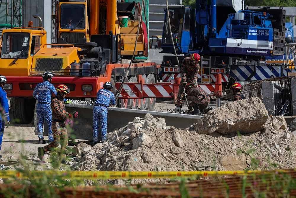 Anggota bomba bersama agensi penyelamat yang lain melakukan kerja-kerja mencari dan menyelamat mangsa tertimbus dalam runtuhan sebuah gudang logistik yang sedang dalam pembinaan di Batu Maung, Bayan Lepas pada Rabu. - Foto: Bernama