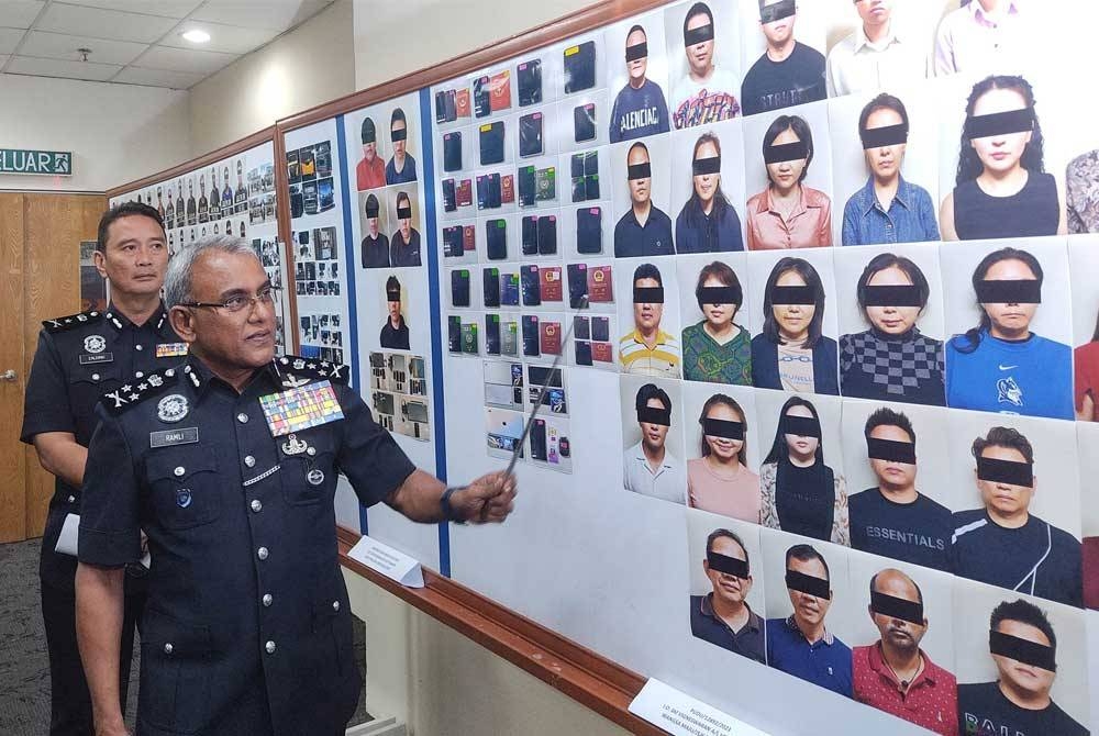 Ramli menunjukkan gambar tangkapan disyaki ahli sindiket tipu pelaburan menerusi serbuan di sebuah banglo di Kuala Lumpur, 22 November lalu.