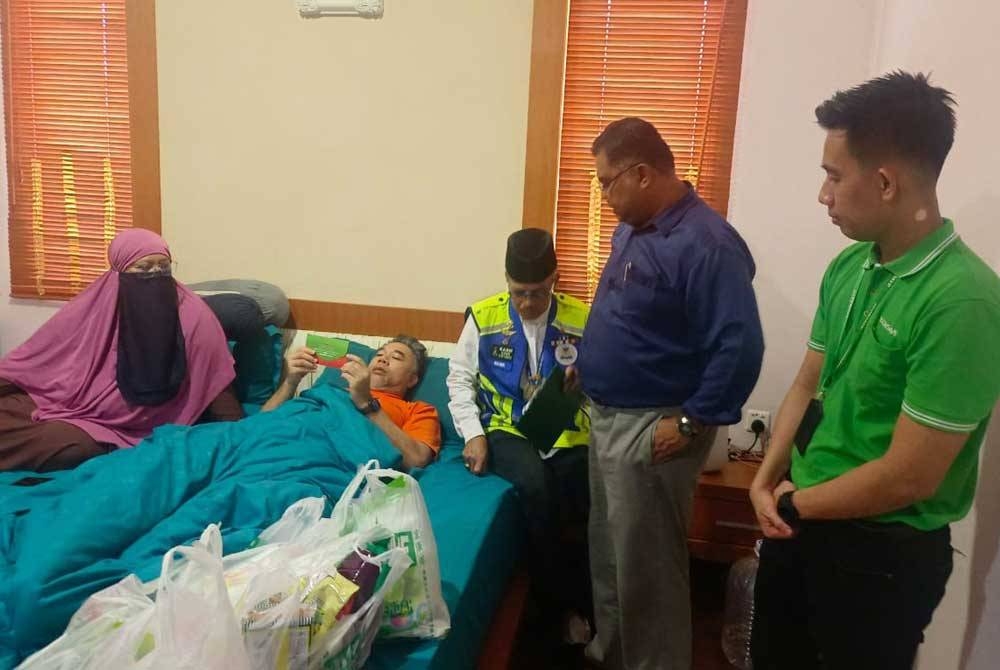 Mohd Nasir (kanan) dan Mas Imran menyampaikan sumbangan kepada Zek bagi meringankan beban keluarga di rumah sewanya di Taman Impian Emas, Johor Bahru pada Rabu