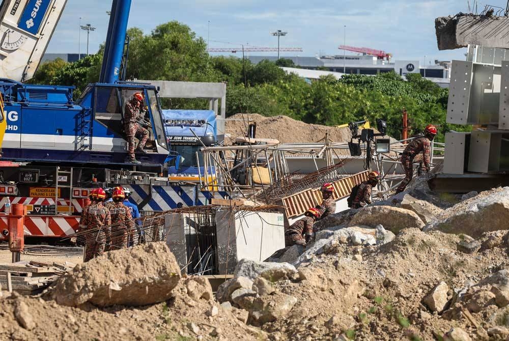 Anggota bomba bersama agensi penyelamat yang lain melakukan kerja-kerja mencari dan menyelamat mangsa tertimbus dalam runtuhan sebuah gudang logistik yang sedang dalam pembinaan di Batu Maung, Bayan Lepas. - Foto Bernama