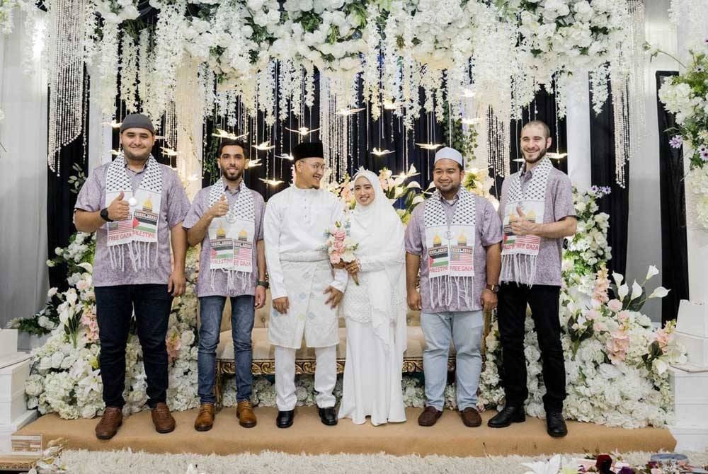 Muhammad Nadir (dua dari kanan) bersama tiga rakannya dari Palestin yang berpakaian sedondon bergambar bersama pasangan pengantin pada majlis resepsi baru-baru ini.