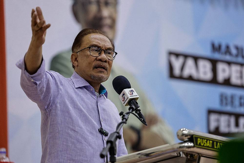 Anwar berucap pada Majlis Ramah Mesra Bersama Komuniti Felda dan Ketengah Terengganu di Dewan Serbaguna Felda Seberang Tayor, malam Rabu. - Foto Bernama