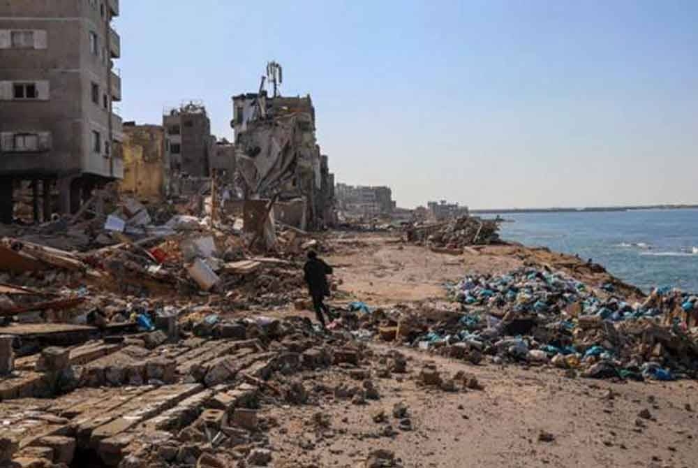 Seorang lelaki berjalan di bangunan yang musnah akibat diserang tentera rejim Zionis Israel di Kota Gaza. - Foto AP