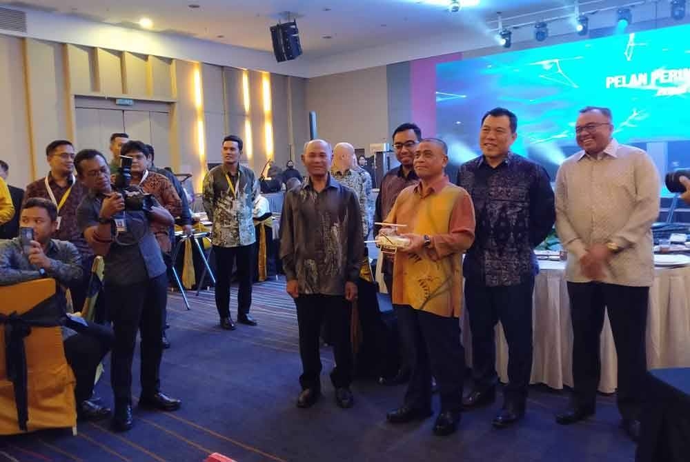 Saarani (tiga dari kanan) mengendalikan dron sebagai gimik pelancaran Pelan Perindustrian Perak sempena Majlis Makan Malam Penghargaan Pelabur 2023 di sebuah hotel pada malam Rabu.