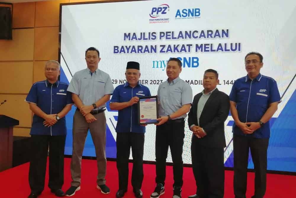 Abdul Hakim (tiga dari kiri) menyampaikan sijil penghargaan kepada ASNB atas kolaborasi ejen kutipan zakat menerusi aplikasi myASNB.