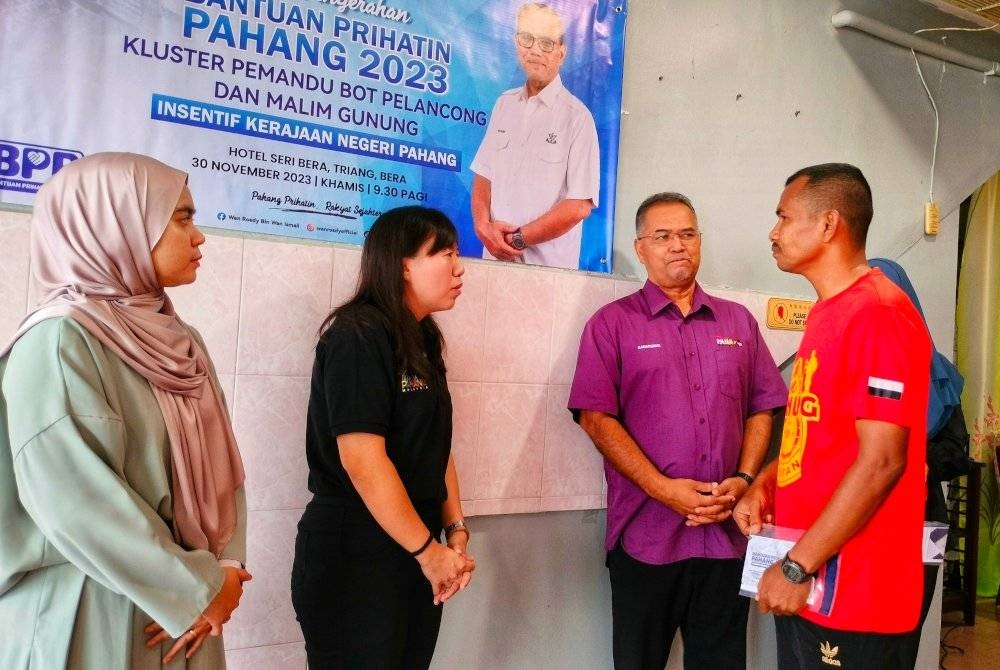 Yu Man (dua dari Kiri) bertanyakan sesuatu terhadap penerima BPP terlibat dalam majlis tersebut pada Khamis.