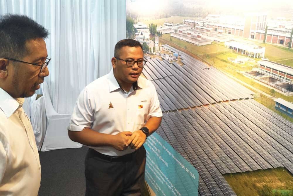 Abas (kiri) mengiringi Amirudin (kanan) semasa melawat ruang pameran semasa Majlis Pelancaran Visi Tenaga Net Zero 2040 di LRA SSP2, Jalan Bukit Badong di sini pada Khamis.