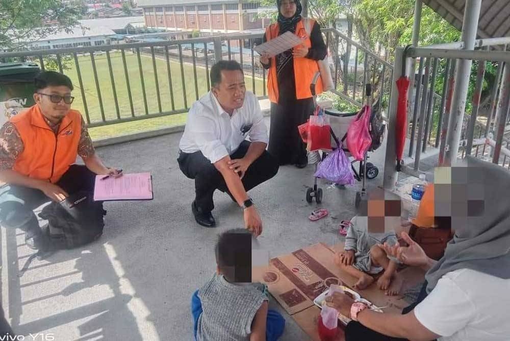 Wanita bersama dua anak yang menghuni di jejantas di Skudai di sini diselamatkan JKM pada Khamis.- Foto tular