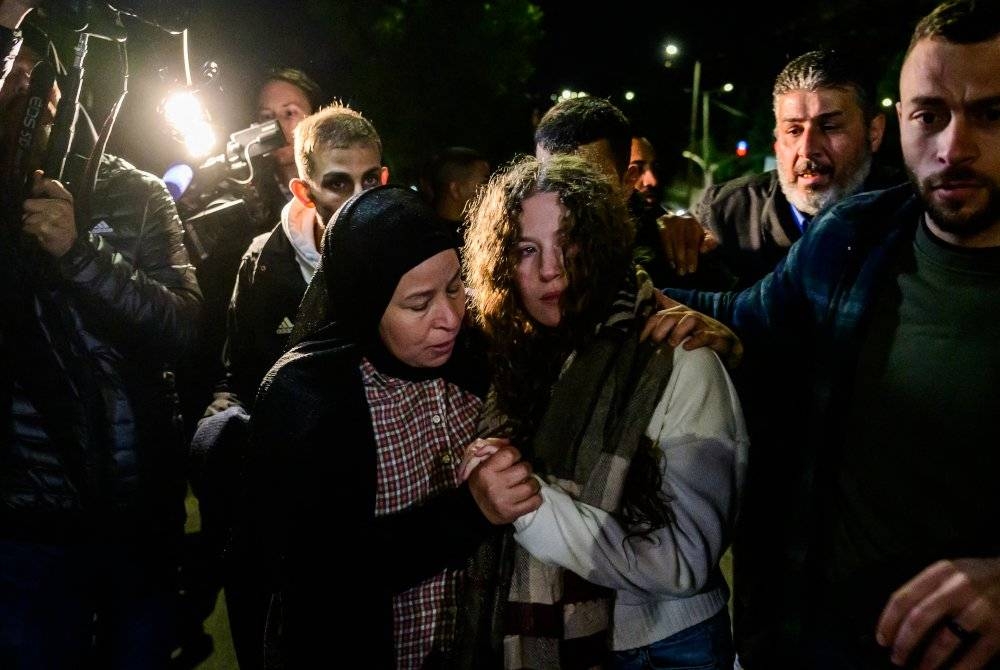 Ahed Tamimi (tengah) disambut keluarganya selepas dibebaskan dari penjara Israel sebagai pertukaran tebusan Hamas-Israel. - AFP