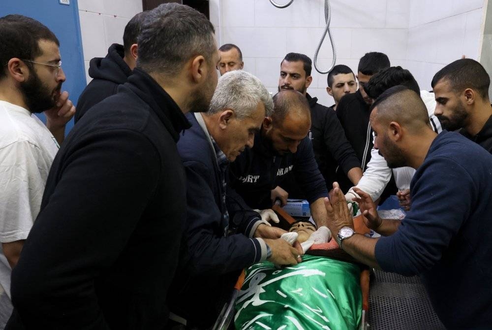 Saudara-mara membawa mayat Bassem Abu Al-Wafa di Hospital Jenin selepas dia meninggal dunia semasa pertempuran dengan tentera Israel, di bandar Jenin, Tebing Barat pada Rabu. - Foto EPA