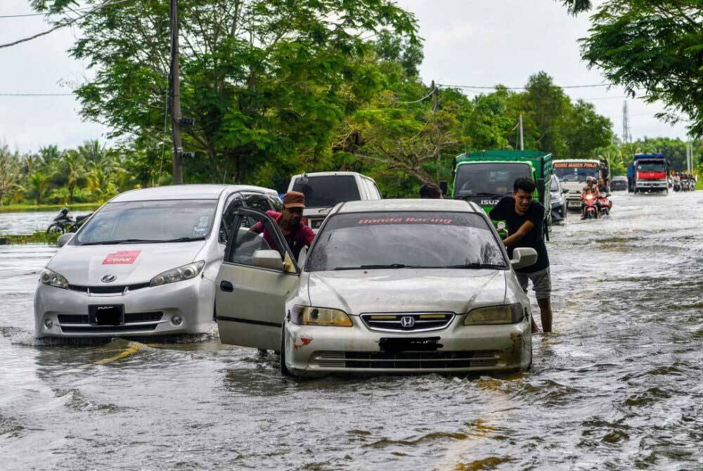 Pemandu kenderaan mengharungi air yang melimpahi Jalan dekat Kampung Sri Sentosa, Bachok berikutan banjir kilat ketika tinjauan pada Khamis. - Foto Bernama