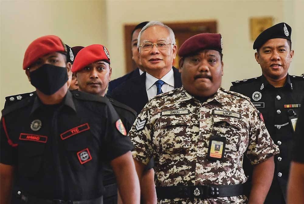 Najib (tengah) hadir di Mahkamah Tinggi pada Jumaat untuk sebutan kes berhubung tiga pertuduhan pengubahan wang haram membabitkan dana SRC berjumlah RM27 juta. - Foto Bernama