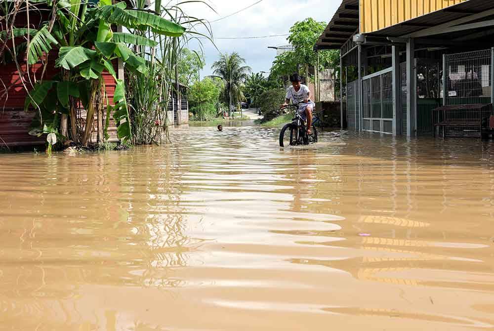 Kelihatan kanak-kanak bermain air bah ketika banjir melanda di Kampung Pasir, Johor Bahru ketika tinjauan pada Jumaat. - Foto Bernama