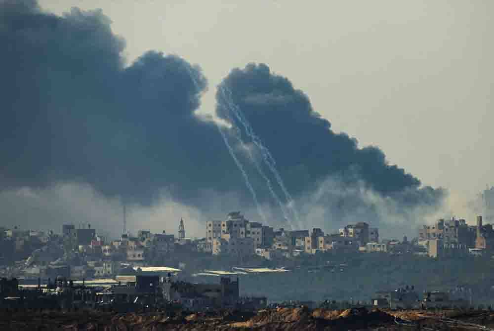 Kelihatan asap berkepul dari bangunan selepas terkena serangan Israel pada Jumaat. - Foto AFP