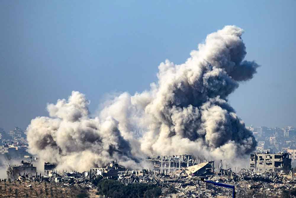 Gambar diambil dari selatan Israel berhampiran sempadan Semenanjung Gaza menunjukkan asap berepul dari bangunan selepas serangan Israel pada Jumaat. - Foto AFP