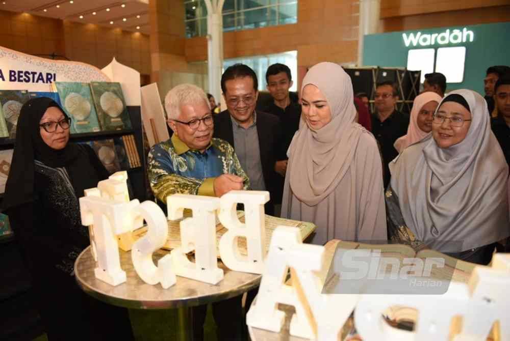 Tengku Permaisuri Norashikin berkenan melawat reruai disediakan di pekarangan konvensyen disambut mesra oleh Hussamuddin yang turut memberikan penjelasan mengenai lembaran naskah al-Quran terbitan Karya Bestari. - FOTO SINAR HARIAN/ MOHD RAFIQ REDZUAN HAMZAH