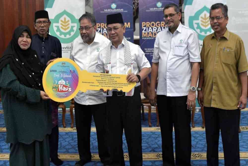 Mohd Na&#039;im (tiga dari kanan) menyampaikan replika kunci rumah penerima bantuan Inspirasiku MyHaus Sasiah Jasli (kiri) pada Program Ziarah Madani YaPEIM Selangor di Masjid Al-Hidayah Telok Panglima Garang, pada Sabtu. - Foto Bernama