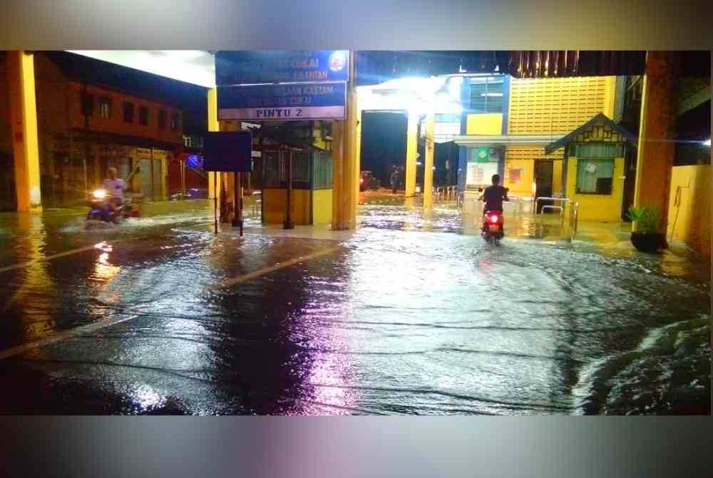 Air dari Sungai Golok mulai melimpah ke kawasan Pusat Pemeriksaan Jabatan Kastam Diraja Malaysia di Rantau Panjang. - Foto pembaca