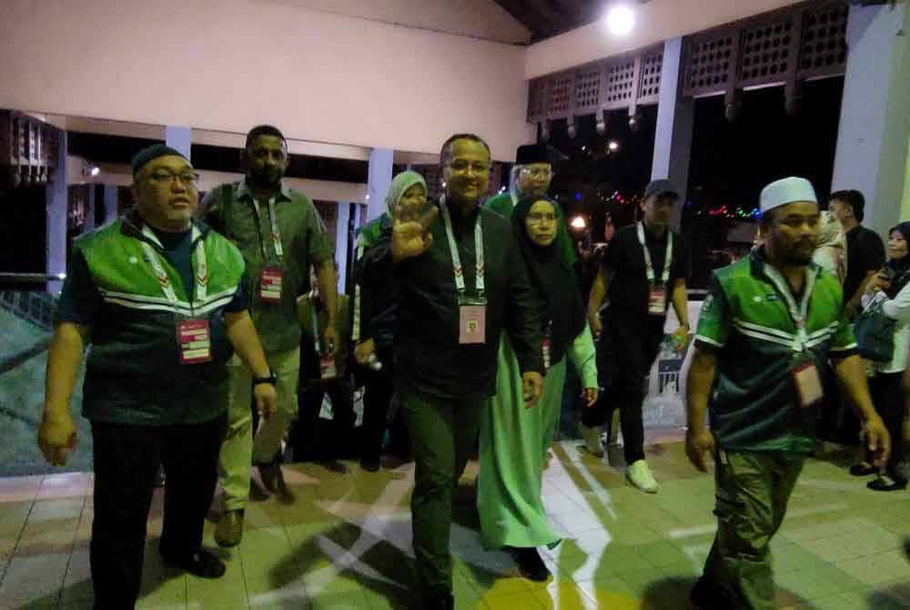 Ahmad Samsuri (tengah) sewaktu tiba di pusat penjumlahan undi di Dewan Berlian Utama, Majlis Perbandaran Kemaman pada malam Sabtu.