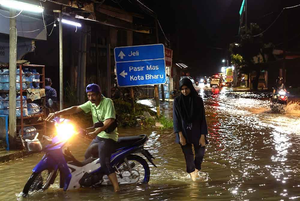 Penduduk yang tinggal berhampiran Sungai Golok, Rantau Panjang melakukan aktiviti harian seperti biasa biarpun beberapa kawasan tanah rendah mula dilimpahi air Sungai Golok ketika tinjauan malam tadi. - Foto Bernama