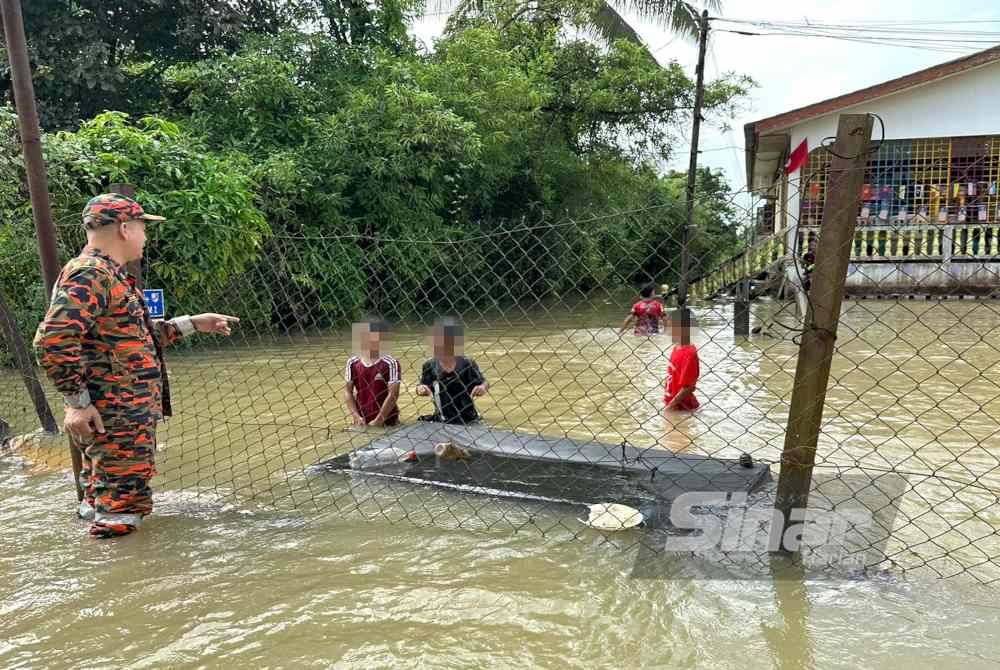 Pihak bomba yang turut menasihatkan kanak-kanak yang bermain banjir di Rantau Panjang.